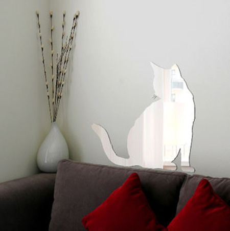 cat mirror sticker on the wall above a sofa