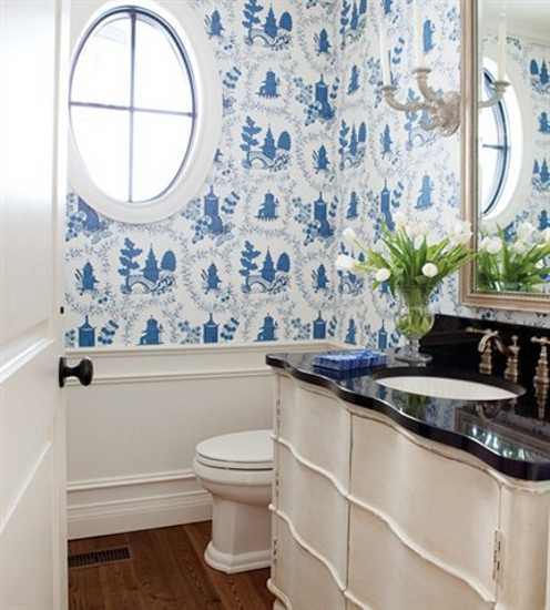 white and blue bathroom wallpaper and sconces in vintage style