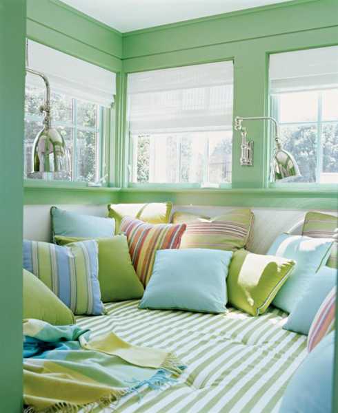 green paint and colorful pillows in pastel colors