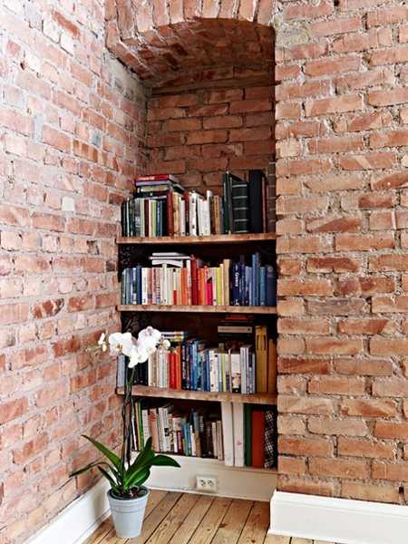 book shelves in brick wall niche