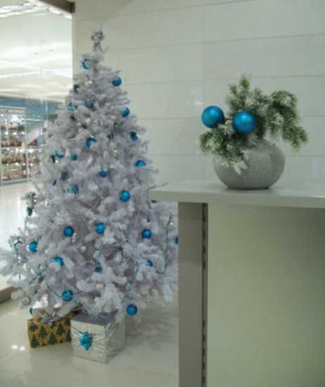 white artificial christmas tree and table centerpiece with blue christmas balls