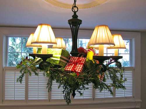 chandelier decoration with green branches and gift boxes