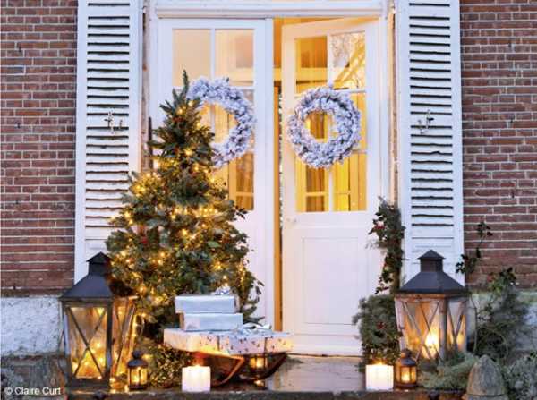 front door decoration for christmas with lanterns, christmas lights and wreaths