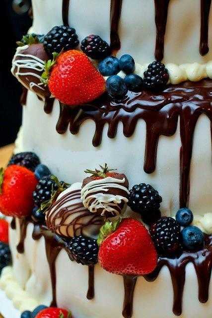 white cake with red, blue and black berries