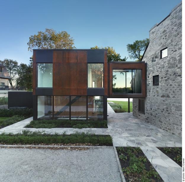 modern house addition connected to old stone wall