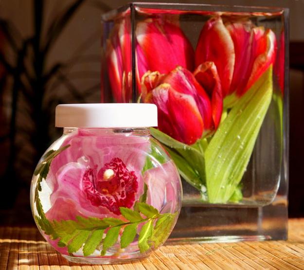 fresh flowers and green leaves preserved in glass jars with glycerol