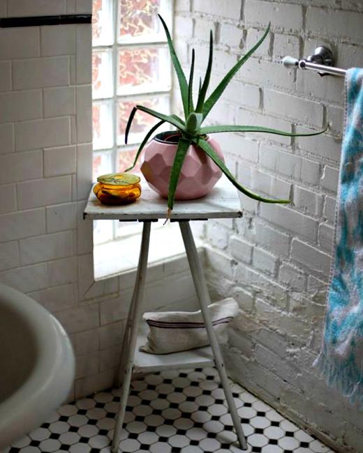 white brick wall and small side table with houseplant