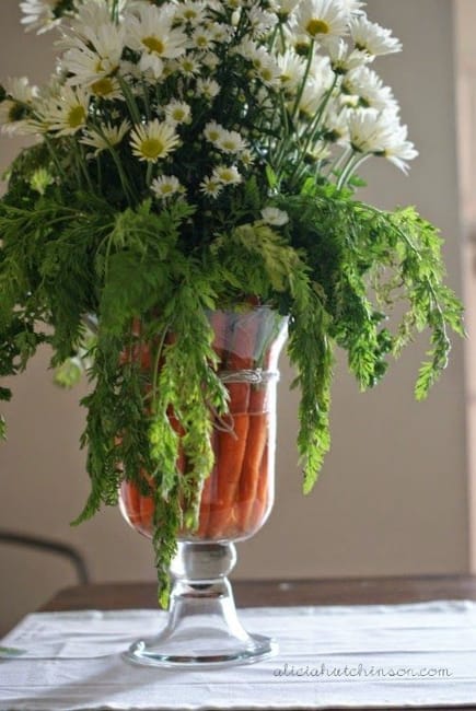 green leaves white flowers carrots table centerpiece